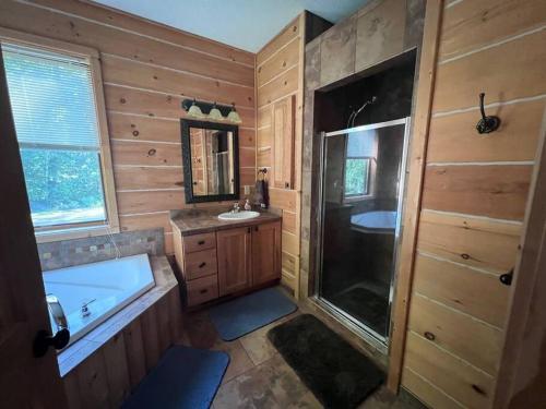 een badkamer met een bad, een wastafel en een douche bij Welcome to Bear's Den Lodge in Round Lake Seaplane Base