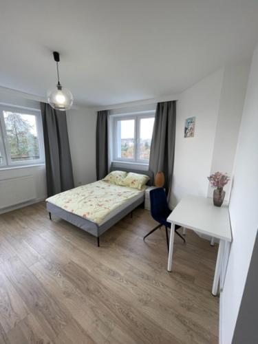 ObłużeにあるGdynia City View Roomsのベッドとテーブルと机のある寝室