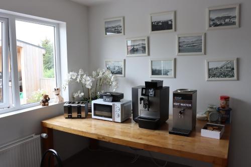 a table with a microwave and a coffee maker on it at Höfn Hostel in Höfn