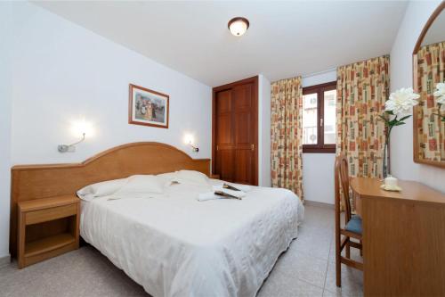 sypialnia z łóżkiem, biurkiem i stołem w obiekcie Apartamentos Xaloc HRC w Cala Millor