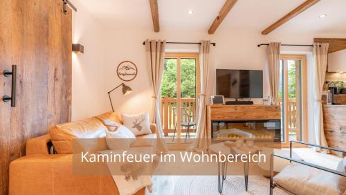 a living room with a couch and a table at Chalet WaldHäusl luxuriöse Ferienwohnungen mit Sauna & Whirlpool, Kamin, Balkon oder Terrasse mit Bergblick in Heiligenblut
