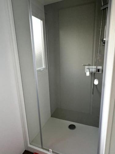 a shower with a glass door in a bathroom at Joli Bungalow 464 pour 4-6 pers Camping Siblu Lac des Rêves Lattes in Pérols