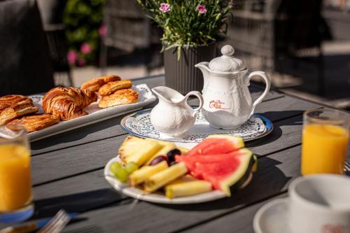 a table with a plate of fruit and a teapot at Hotel AlpinaRos in Berchtesgaden