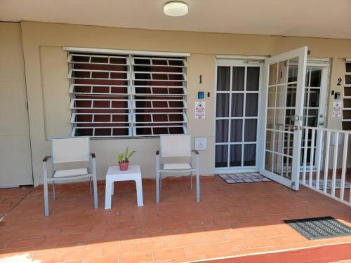 a porch with two chairs and a table and a window at Cozy apartment near the beach #1 in Fajardo