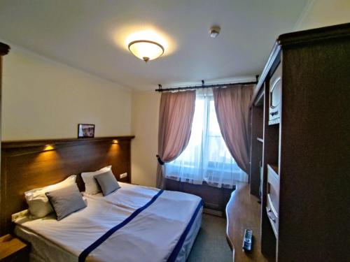 a hotel room with a bed and a window at 7 Pools SPA Boutique Hotel in Bansko