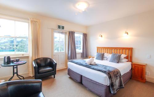 a hotel room with a bed and a chair at The Grand Hotel & Bar - Akaroa in Akaroa