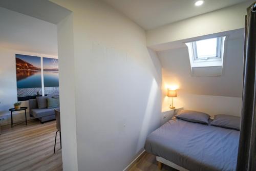 une chambre avec un lit, une fenêtre et un canapé dans l'établissement L'Écrin du Lac, à Annecy