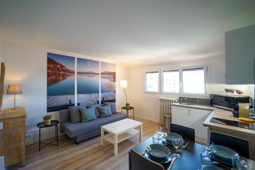 un salon avec un canapé et une cuisine dans l'établissement L'Écrin du Lac, à Annecy