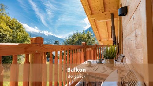 a wooden porch with a table on a deck at Chalet WaldHäusl luxuriöse Ferienwohnungen mit Sauna & Whirlpool, Kamin, Balkon oder Terrasse mit Bergblick in Heiligenblut