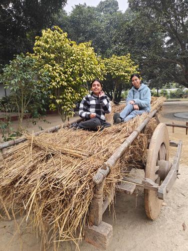 two people sitting on top of a hay cart at Shobhayan inn, airport railway station pickup free in Ayodhya