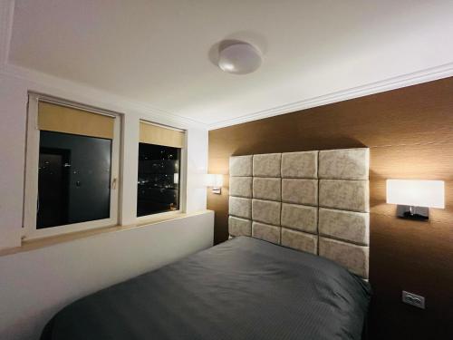 a bedroom with a bed and two windows at Dido House Panoramic -Eurovision Fans Hub 2027 in Veliko Tŭrnovo
