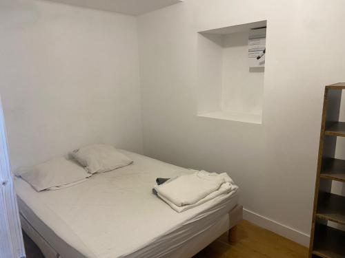 - un petit lit dans un dortoir aux murs blancs dans l'établissement P2 Nîmes ,7 rue Saint Catherine, à Nîmes