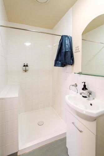 a white bathroom with a sink and a shower at The Grand Hotel & Bar - Akaroa in Akaroa