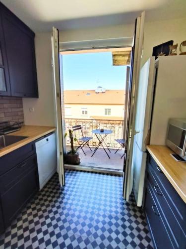 une porte ouverte sur une cuisine avec vue sur un patio dans l'établissement Le Jean-Paule, à Jallieu