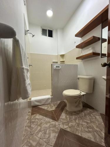 een badkamer met een douche, een toilet en een wastafel bij Suits JA in Puerto Ayora