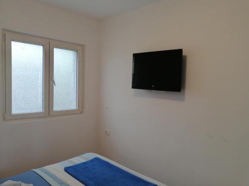 a bedroom with a flat screen tv on the wall at Apartments Željka-Dobrota in Kotor