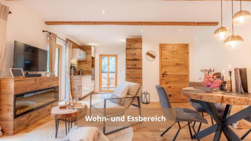 a living room with wooden walls and a dining room at Chalet WaldHäusl luxuriöse Ferienwohnungen mit Sauna & Whirlpool, Kamin, Balkon oder Terrasse mit Bergblick in Heiligenblut