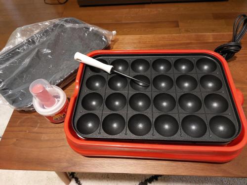 a red tray with balls in it on a table at つきびとはうす in Satte