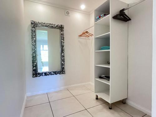 a mirror on a wall next to a closet at Beach Melody, Umdloti South Beach, king Bed in Umdloti