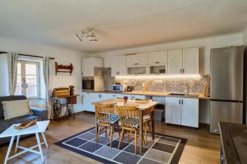 a kitchen with white cabinets and a table and chairs at Chaloupka na Šumavě in Konopiště