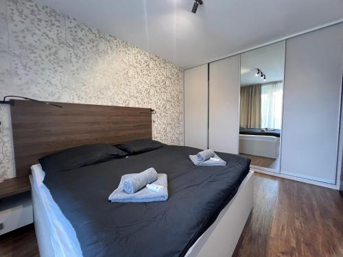a bedroom with a bed with two towels on it at Apartmán Manhattan s terasou v centre mesta in Trenčín