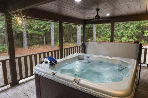 a jacuzzi tub on the deck of a house at NewListing! 1-Mile Choctaw Landing, GameRoom, 6BR, Sleep-18, PET Friendly, HotTub, Play Structure, Smart TV, FirePit, Outdoor in Stephens Gap