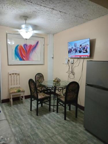 a dining room with a table and chairs at The Golden Triangle with pool in Liguanea
