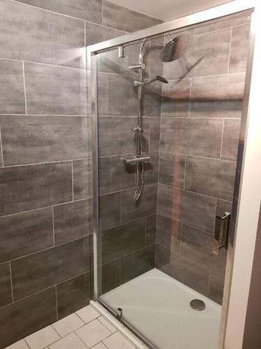 une douche avec une porte vitrée dans une salle de bain dans l'établissement Superbe chalet Hautes Vosges, à Cornimont