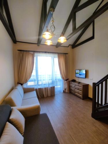 a living room with a couch and a television at 7 Pools SPA Boutique Hotel in Bansko