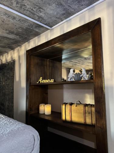 a bedroom with a mirror and a bed with candles at Victoria Tiny Stone House in Ponta do Pargo