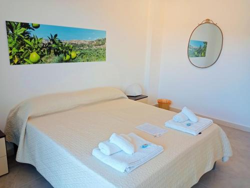 Un dormitorio con una cama con toallas. en Niche Apartment, en Noto