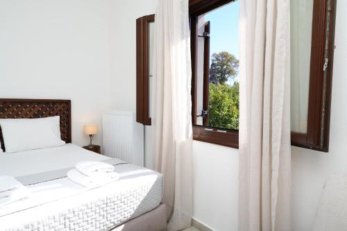 a bedroom with a bed and a window at Marousos Central Guesthouse in Portariá