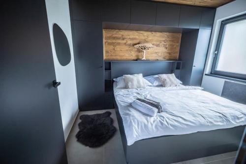 a small bedroom with a bed with white sheets at Bungalov Kanada Point in Kunžak
