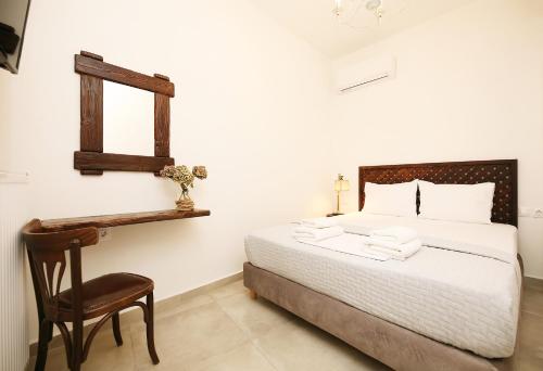 a bedroom with a bed and a chair and a mirror at Marousos Central Guesthouse in Portariá