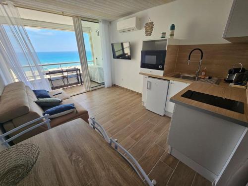 a kitchen and living room with a view of the ocean at Appartement 4 pers vue mer le barcares in Dosse Gros
