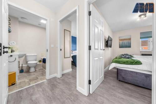 a bedroom with a bed and a bathroom at Elegant 2Bed Sleeps 4 With Parking in Paisley