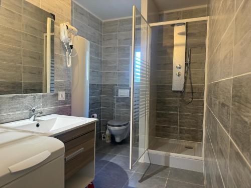 une salle de bain avec une douche, un lavabo et des toilettes dans l'établissement Nid douillet, à Villemoustaussou