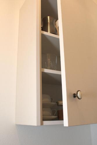 a white cabinet with plates and dishes in it at Marousos Central Guesthouse in Portariá