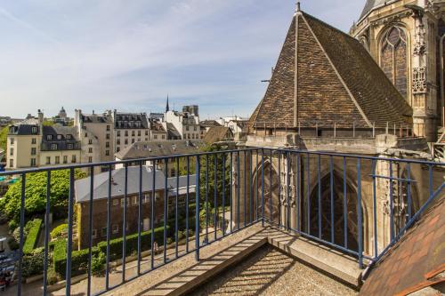 a balcony with a view of a cathedral at MIJE MARAIS Hostel in Paris