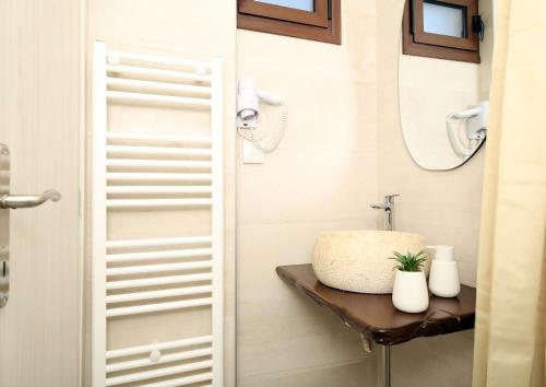 a bathroom with a sink and a mirror at Marousos Central Guesthouse in Portariá