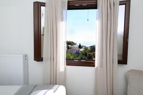 a bedroom with a window with a view at Marousos Central Guesthouse in Portariá
