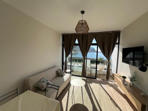 a living room with a couch and a large window at Cura Sea View Apartment in Playa del Cura