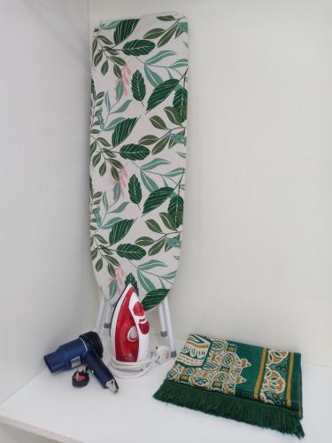 a shelf with a shower curtain and a towel at The Straits Suites by Ciconia in Melaka