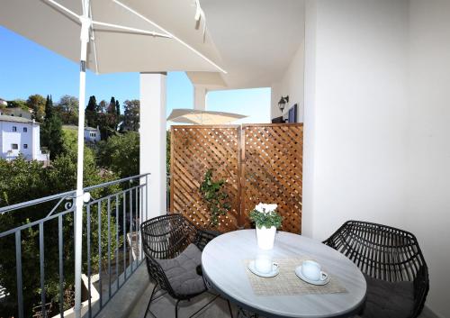 a table and chairs on a balcony with an umbrella at Marousos Central Guesthouse in Portariá