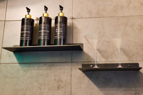 a shelf with wine bottles and glasses on a wall at Green Garden Děčín in Děčín