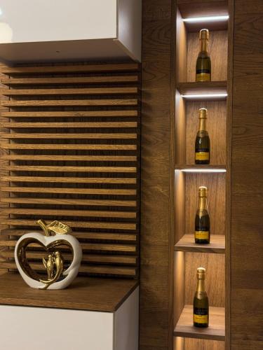 a wine cellar with bottles and a heart on the shelf at Apartman Madness in Bijeljina