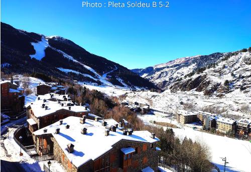 a building with snow on top of it in the mountains at AC Apartaments Pleta Soldeu in Soldeu
