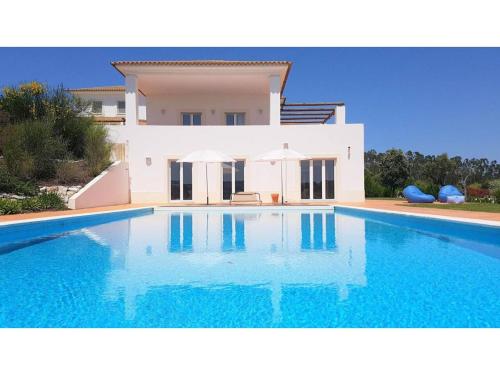 a large swimming pool in front of a villa at Villa Martin in Óbidos