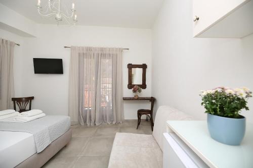 a white room with a bed and a mirror at Marousos Central Guesthouse in Portariá