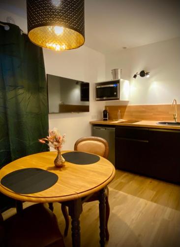 Il comprend une cuisine avec une table en bois et un évier. dans l'établissement Love Room Plaisir Secret, à Limoges
